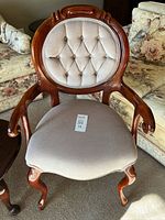 Front view of accent chair showing wood frame, tufted back, upholstered seat