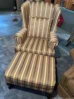 Front view of striped armchair with pillow and ottoman