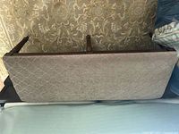 Bench underside showing upholstery pattern and wood frame