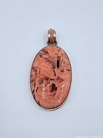 front view of pendant showing pink agate cabochon and bail