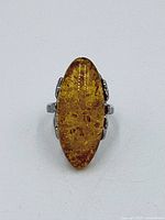 Front view of sterling silver ring showing marquise amber cabochon
