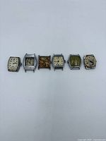 Front view of six wristwatch heads laid in a row