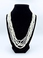 Necklace displayed on stand showing multi strands of pearls