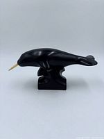 Left side profile of stone narwhal on base