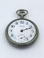 Front view of New Era pocket watch showing dial and cracked crystal