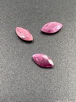 Three marquise rubies on textured surface
