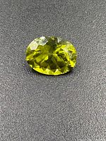 Close-up of oval faceted yellow-green sphene