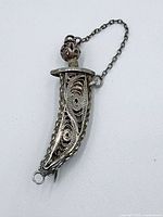 Brooch assembled in sheath showing filigree detail and chain