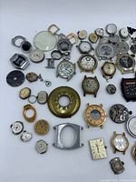 Overview of assorted watch cases, movements and crystals
