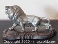 Left front view of lion figurine on base