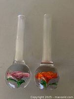 Front view of both Murano glass vases showing flower colors and paperweight bases