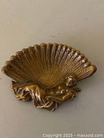 Front view showing scalloped fan dish and reclining female figure