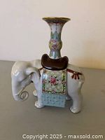 Side view showing elephant figurine and attached vase