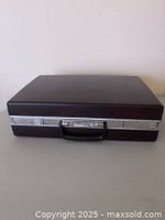 Front view of closed Samsonite attaché showing black faux leather exterior and handle