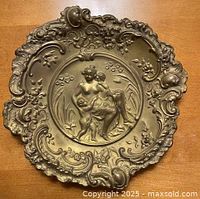 Top view showing embossed classical scene and ornate rim