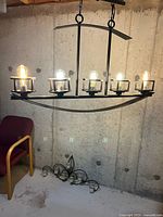 Full view of chandelier with five bulb positions installed in unfinished room