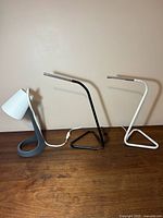 Group view of three IKEA desk lamps: SVALLET, black HARTE, white HARTE