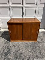 Front view of walnut cabinet showing sliding doors and pulls