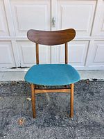 Front view of chair showing wood frame, curved backrest, blue seat