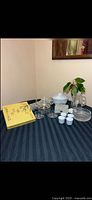 Overview of all items on table including porcelain, cut glass, yellow box