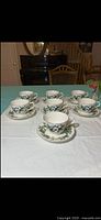 Full set of seven cups each on its saucer arranged on table
