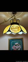 Full view of hanging stained glass lamp illuminated