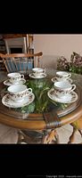 Full set of five teacups and saucers on table
