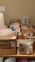 Overview of multiple boxes containing kits, floss packs, thread cones and assorted crafting materials