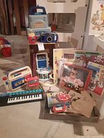 Group shot of entire lot showing cassette recorder, camera, View-Master, VTech device, Casio keyboard, puzzles, record