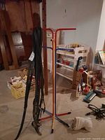Full view of multicolor painted metal coat rack standing on tripod base