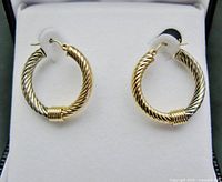 Close-up of both hoop earrings showing two-tone gold, twisted texture, coil wrap, and 14K ear wires