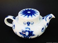 Left front view of Bing & Grondahl flow blue teapot showing lid starburst and body pattern