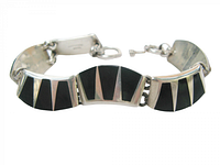 Bracelet close-up showing three curved panels with silver and black onyx inlay and toggle clasp ends