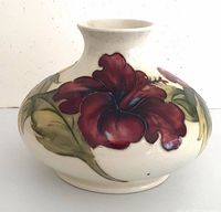 Front view of Moorcroft vase showing red Hibiscus flower on cream background