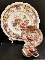 Front view showing plate, cup, saucer and brass stand