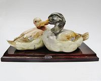 Front view of porcelain duck pair on wood base