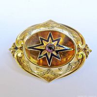 Front view showing star motif, enamel detailing and amethyst cabochon