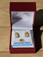 Front view of boxed pair showing opal and diamond studs