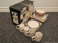 Boxed 16-piece stoneware set with plates, bowls and mugs displayed