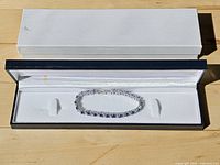 Bracelet displayed inside open blue and white hinged box
