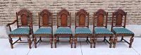 front view of six matching carved oak chairs