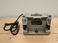 Front view of Shopcraft bench grinder showing wheels, eye shields and cord