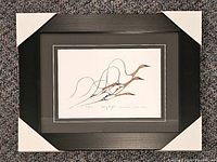 Front view of framed, matted print showing artwork, frame, and corner protectors