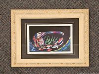 Front view showing artwork, matting and carved frame