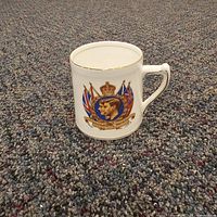 Front of commemorative mug with royal portrait and flags