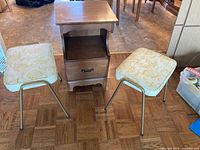 Nightstand centered between two stools on parquet floor