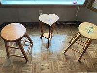 Full view of both stools and heart table on parquet floor