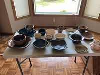 overall view of about 20 handmade pottery pieces on table