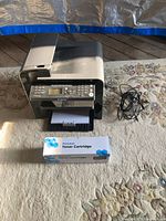 Front view of Canon MF4450 with cables and boxed toner displayed