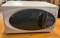 Front view of microwave showing white body and black oval window